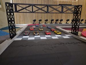 Deelnemers racen op een professionele binnen racebaan met scorebord en begeleiding